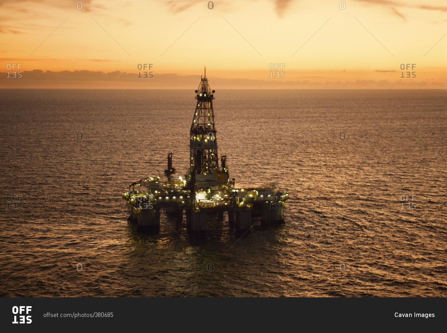 High angle view of oil rig in sea during sunset