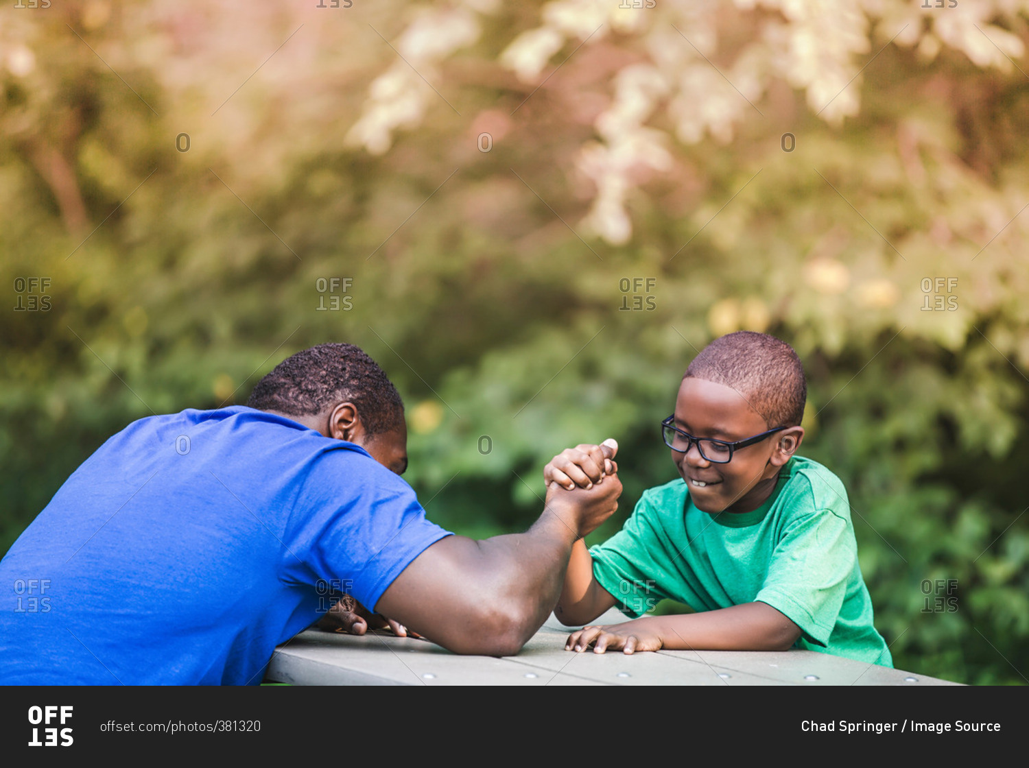 Father arm wrestling with son at parkland eco camp