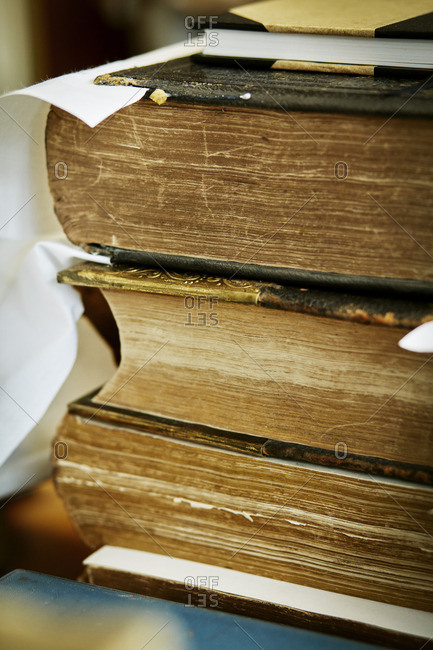 A stack of books, with yellowed worn page edges and worn bindings