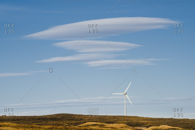 Single windmill on a green plain