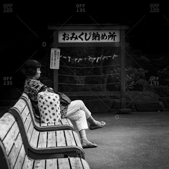 Tokyo, Japan - August 21, 2015: Woman resting on bench in Sugamo