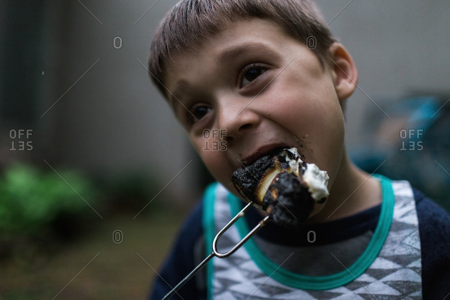 Little boy eating a burnt marshmallow