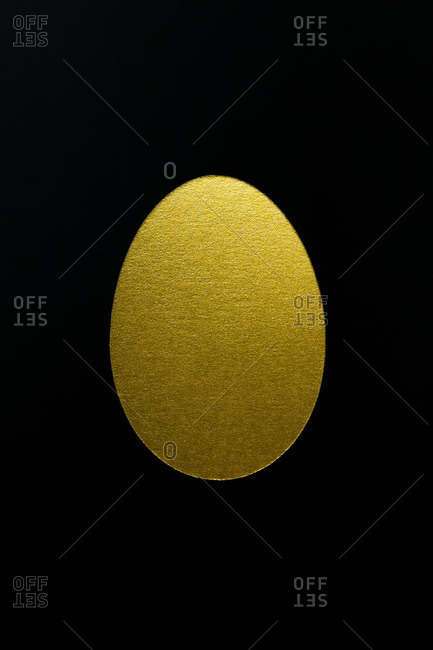 Golden egg on black background