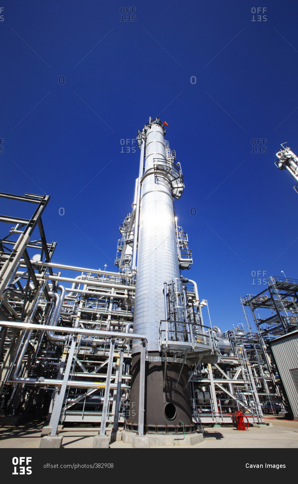 Low angle view of power station against clear blue sky