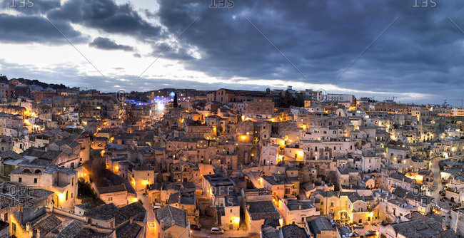 Houses of Sassi di Matera illuminated at dusk, one of the three oldest cities in the world, Matera, Basilicata, Italy