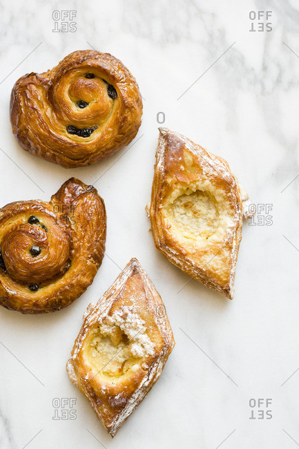 Four French pastries on white marble from above