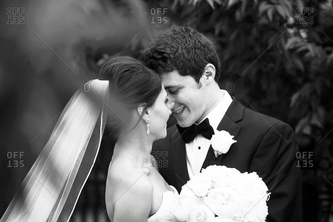 Bride and groom kissing outside