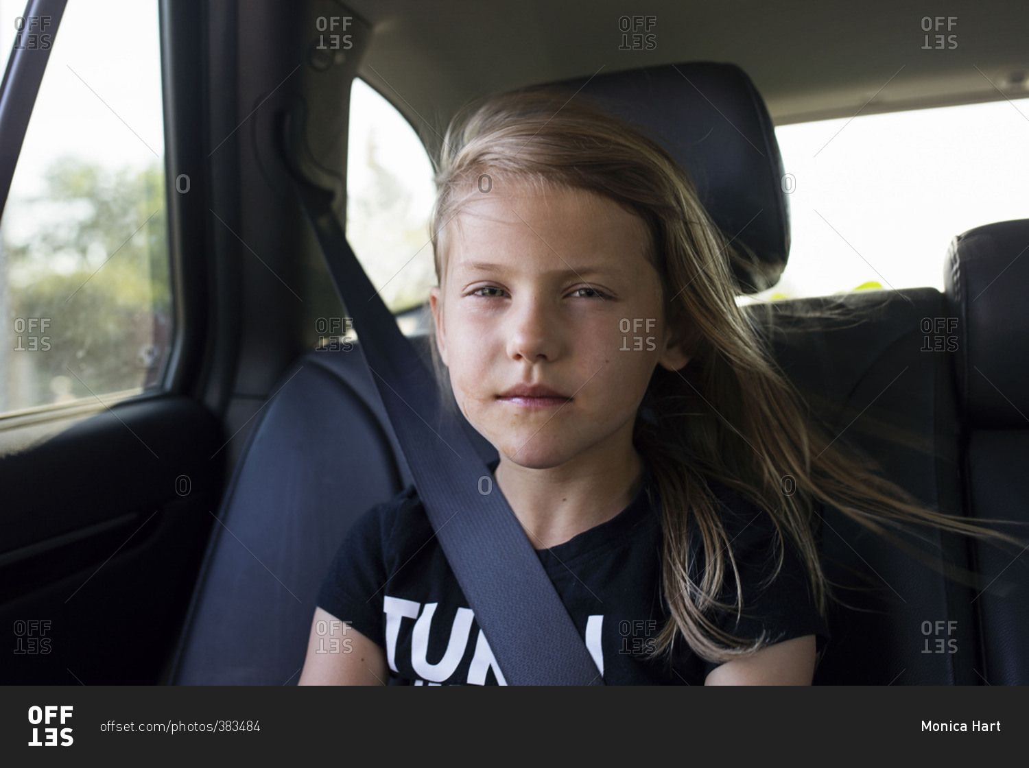 Young girl riding in the backseat of a car stock photo OFFSET