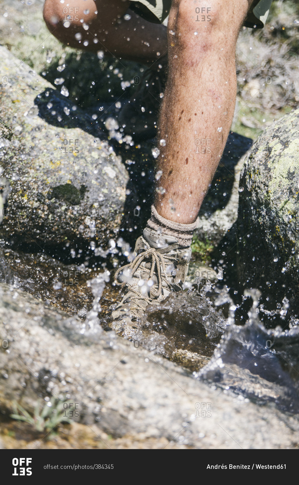 Hiker with a hiking shoe in water splashing