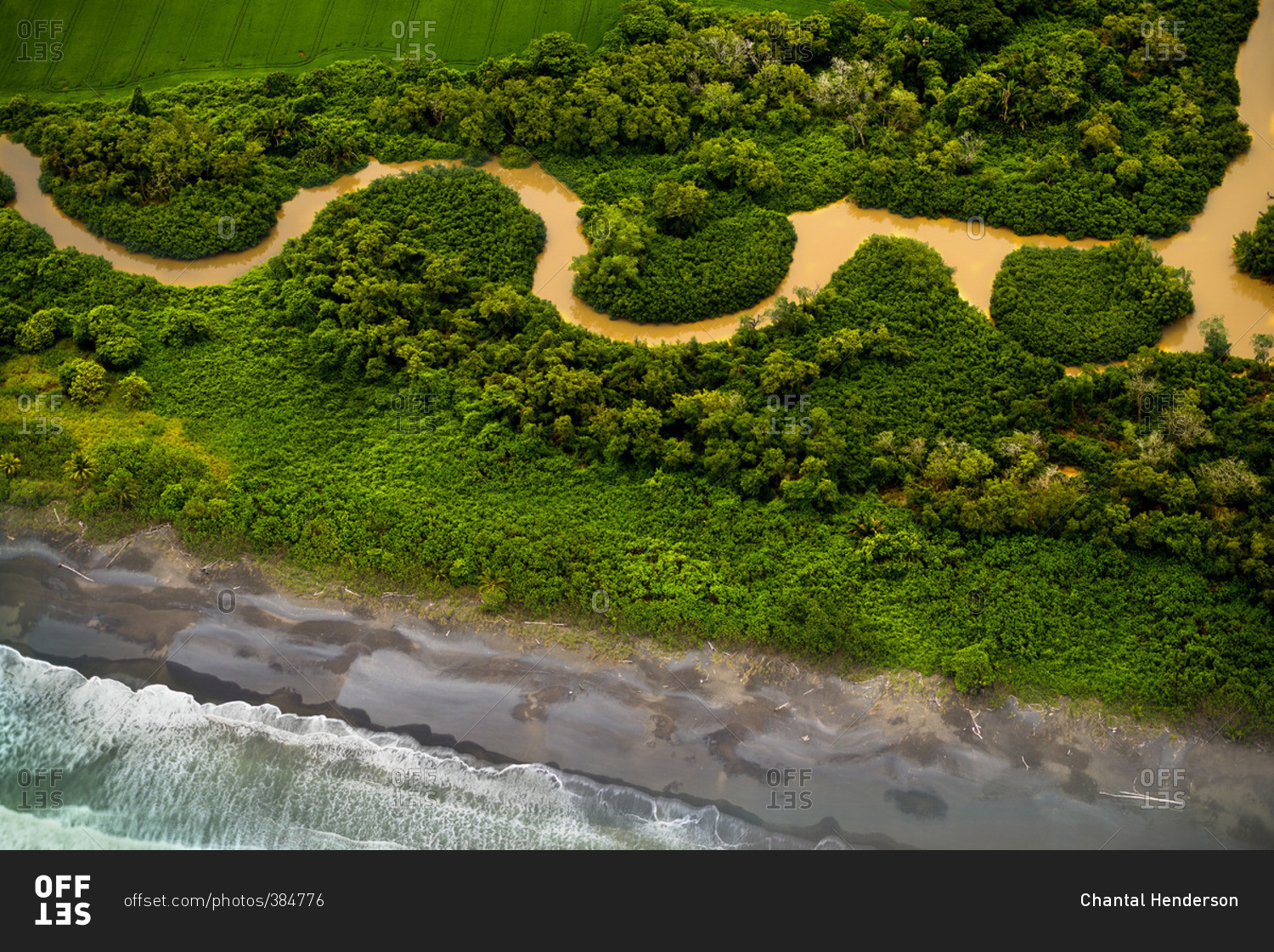 Aerial view of muddy river winding along coast