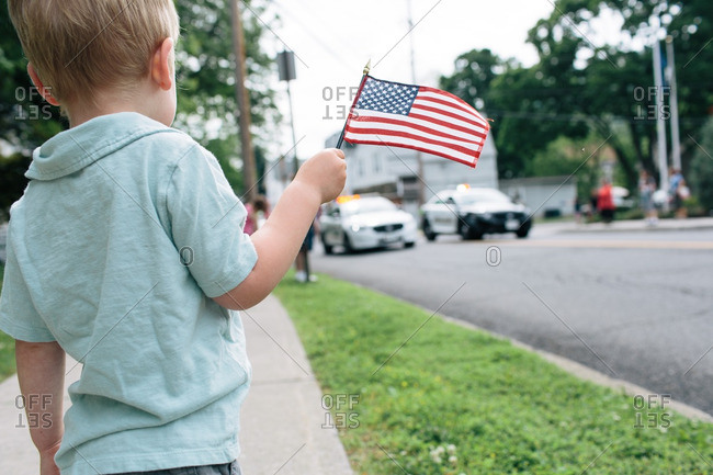 Little boy waving American flag at a parade