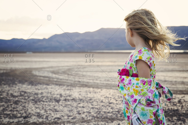Side view of thoughtful girl standing on arid landscape