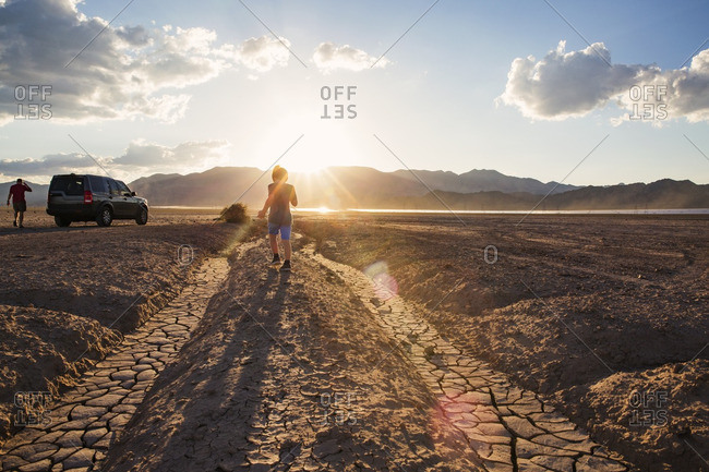 Las Vegas, NV, USA - September 6, 2015: Rear view of boy walking on arid landscape during summer