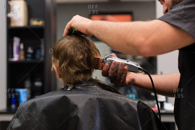 Boy Getting Haircut With Clippers At A Barbershop Stock Photo Offset