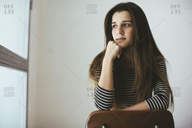 Young woman with ombre hair resting on a chair