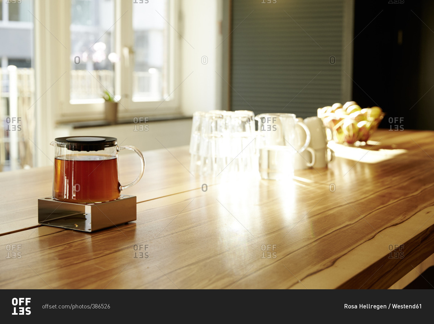 Teapot on teapot warmer on tabletop in a modern office stock photo OFFSET