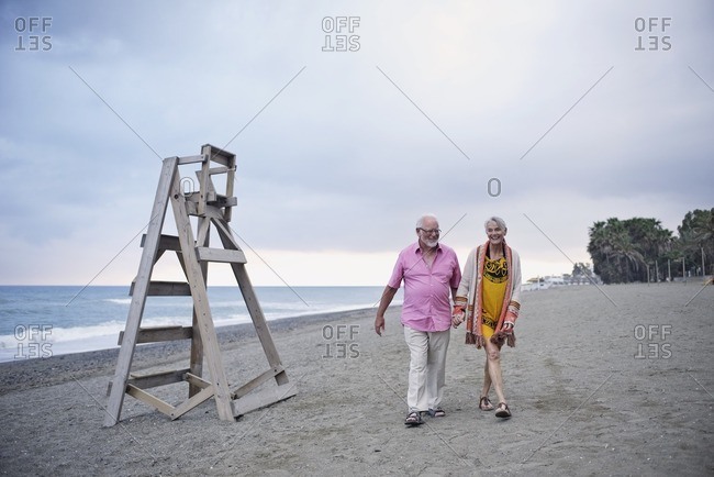 Happy senior couple walking on a sandy beach