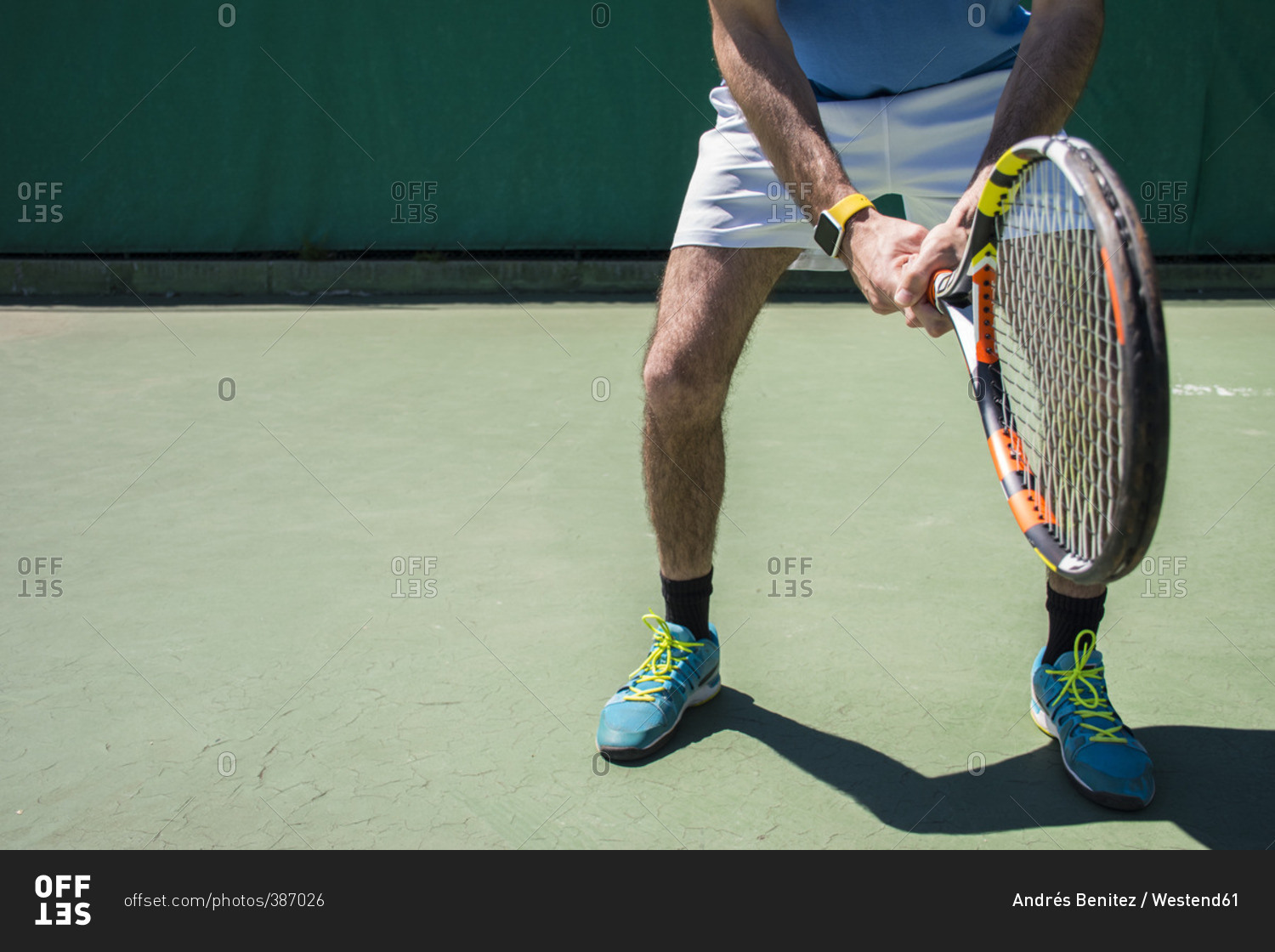 Legs of tennis player with racket