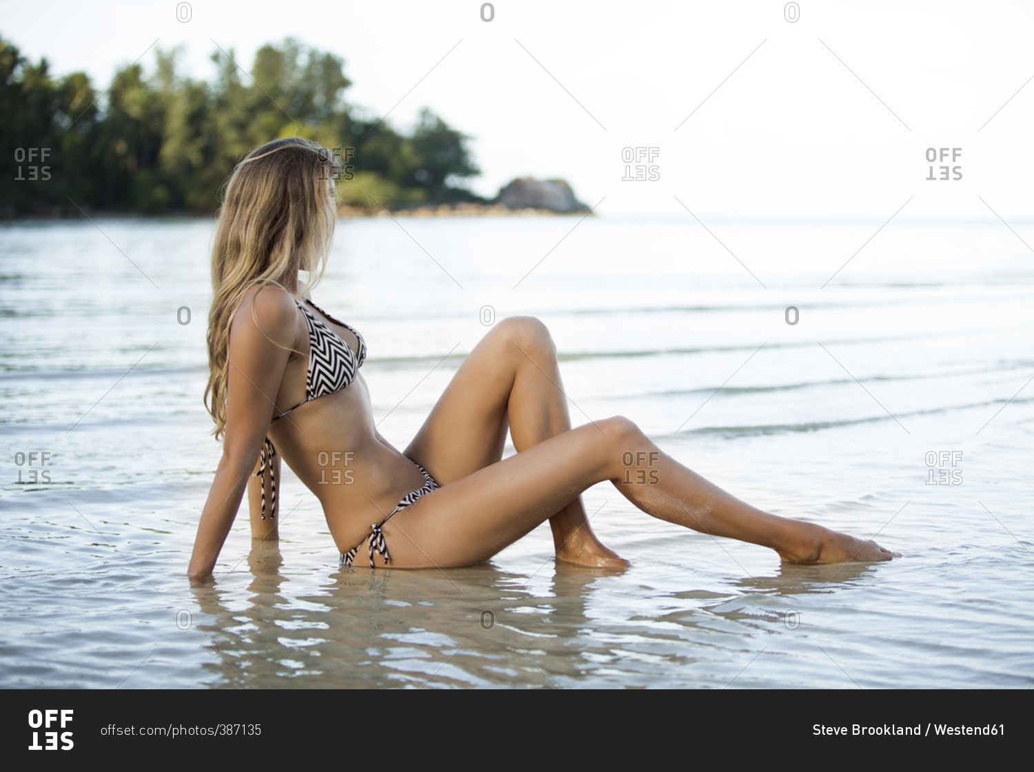 Thailand, woman sitting in shallow water