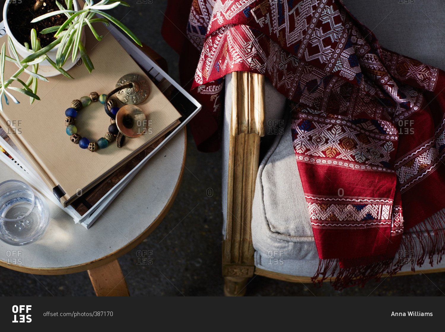 Overhead view of a hand woven blanket on a couch by side table stock