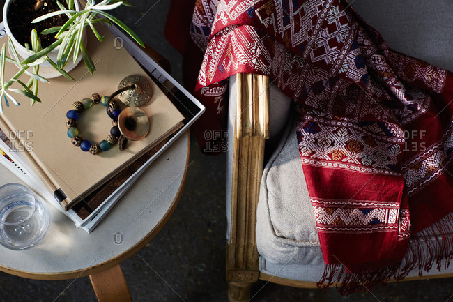 Overhead view of a hand woven blanket on a couch by side table