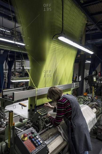 Lyon, France - February 19, 2016: Woman at a weaving machine