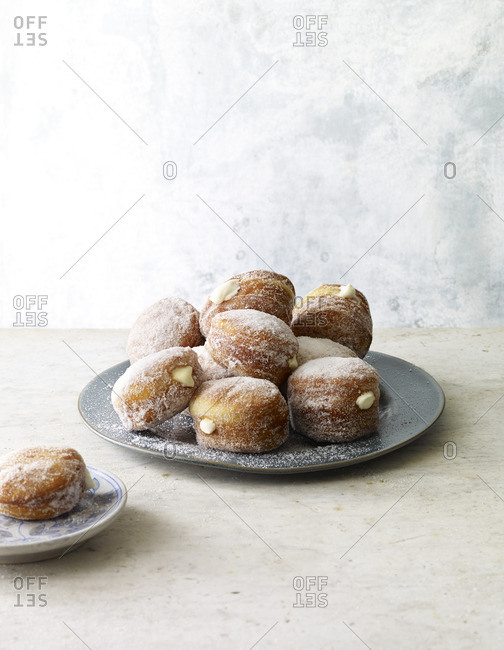 Cream-filled sugary donuts on a serving platter