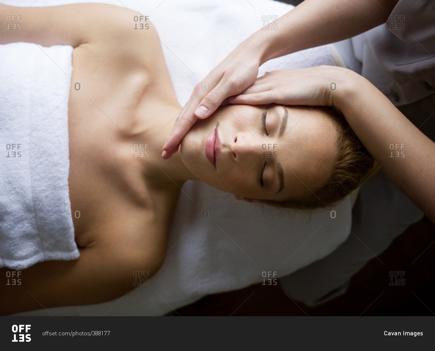 Woman receiving massage from female therapist in spa