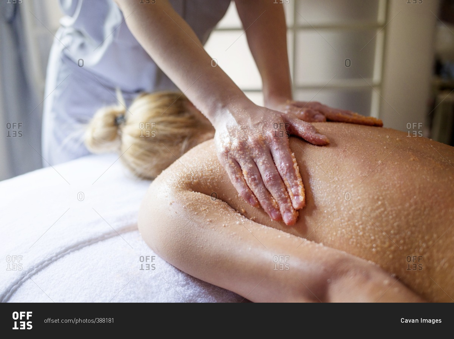 Midsection of therapist massaging woman's back in spa