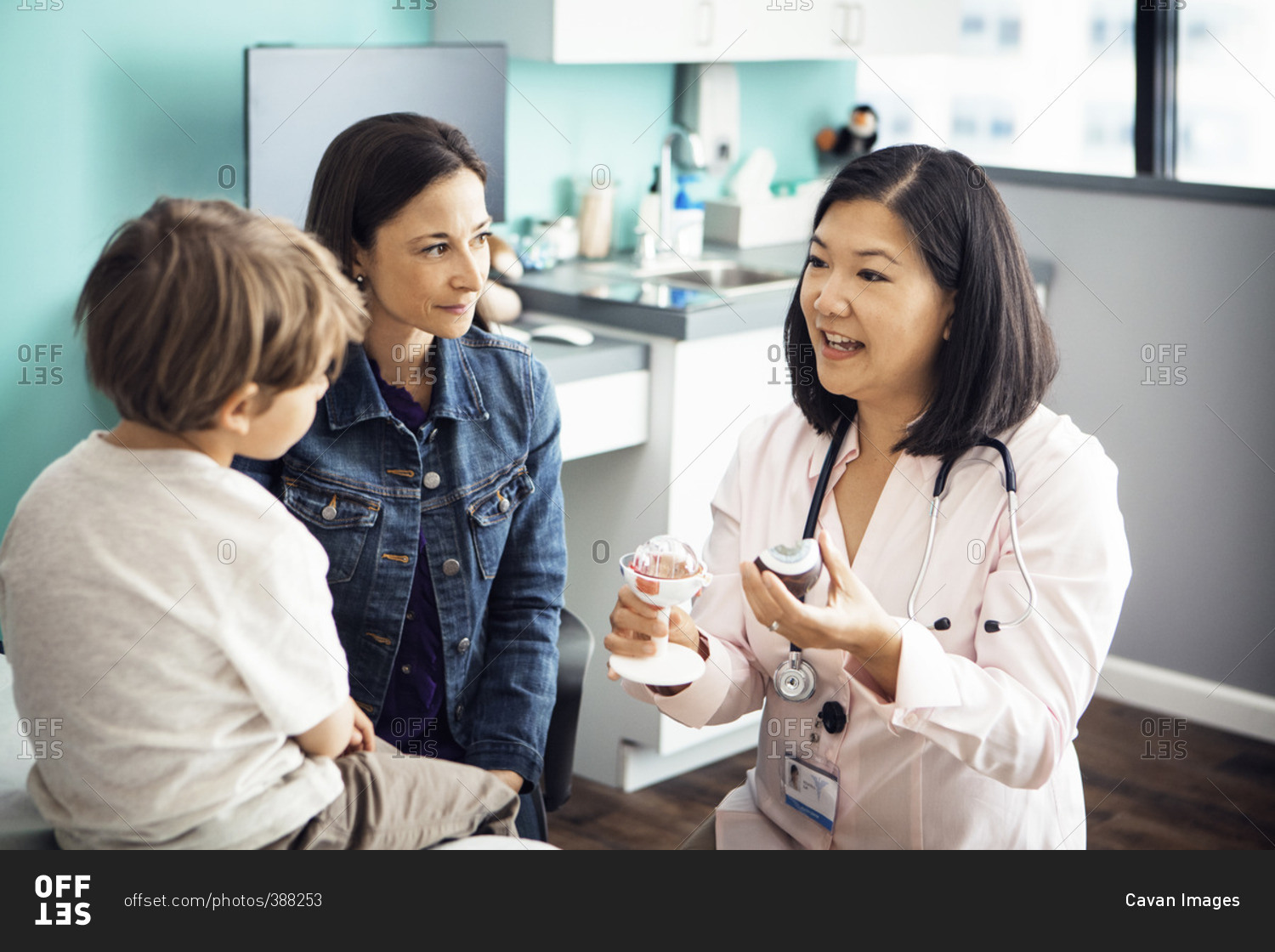 Female doctor explaining medical equipment to family in clinic