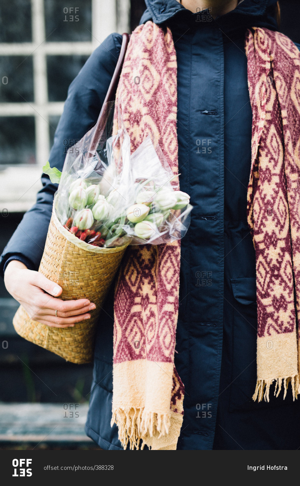 Woman carrying shoulder bag containing bouquet of flowers