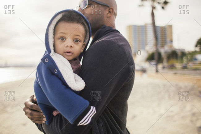 Baby in father's arms at beach