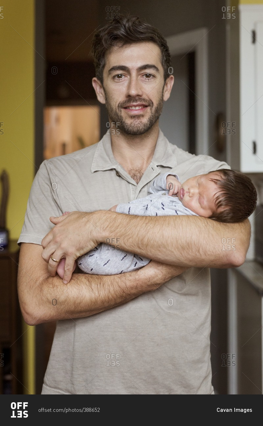 Portrait of happy father carrying baby boy at home stock photo OFFSET