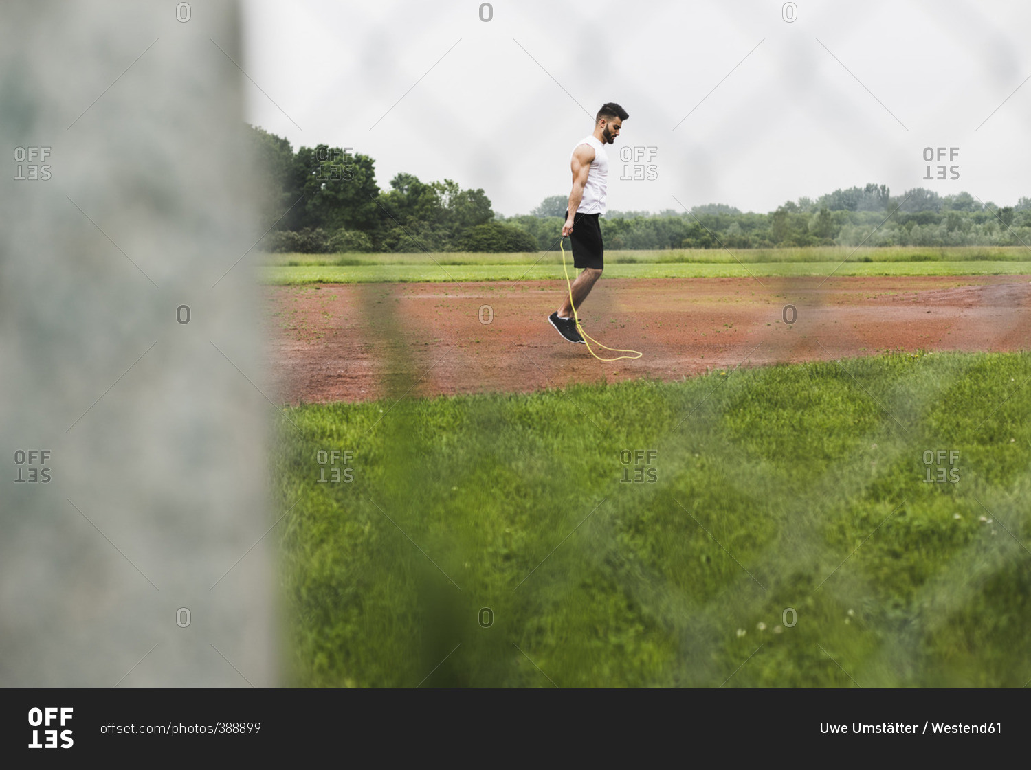 Athlete skipping rope on sports field