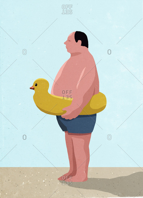 Side view of man wearing inflatable rubber duck ring at beach