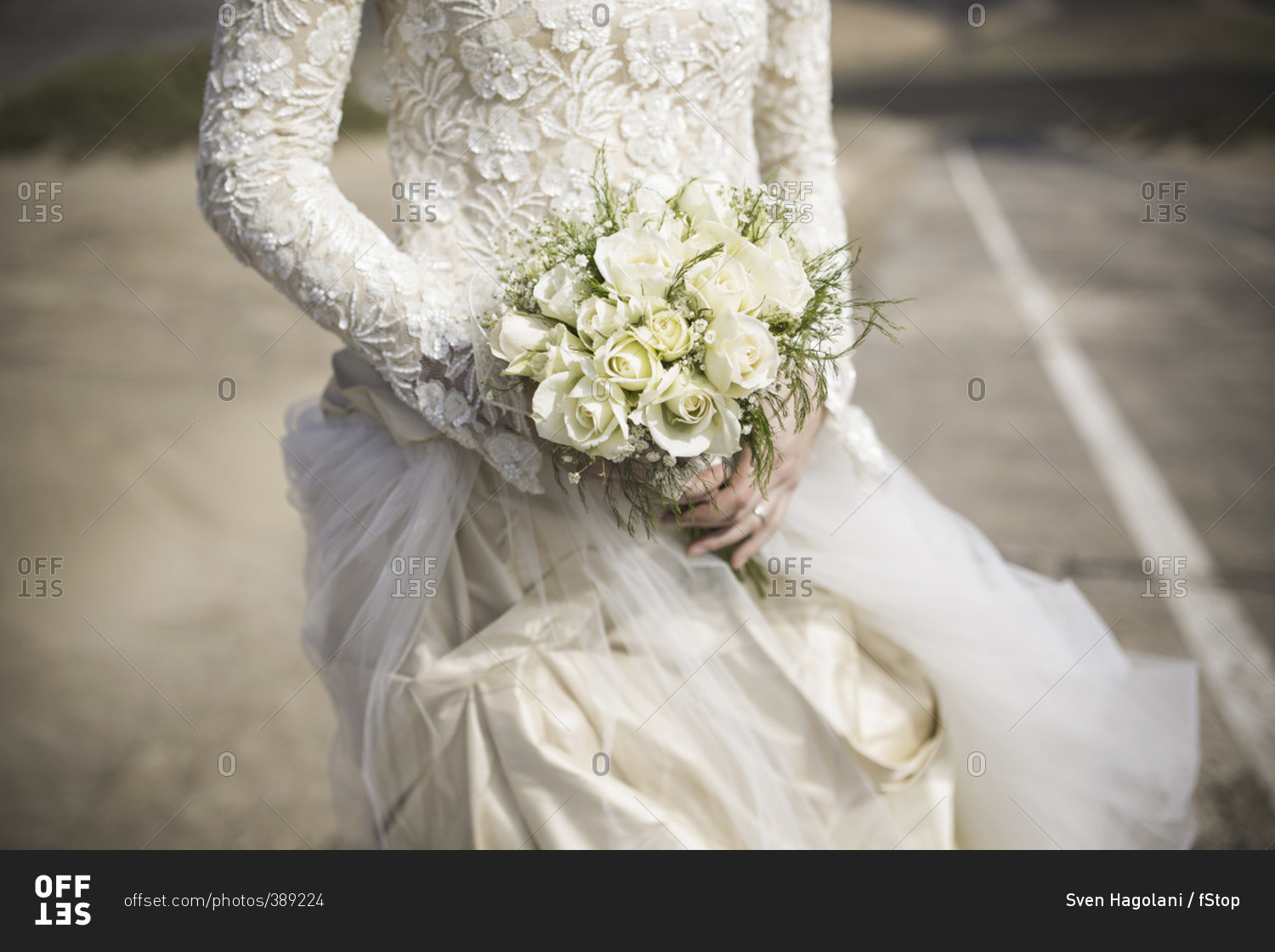 Midsection of bridge holding rose bouquet outdoors