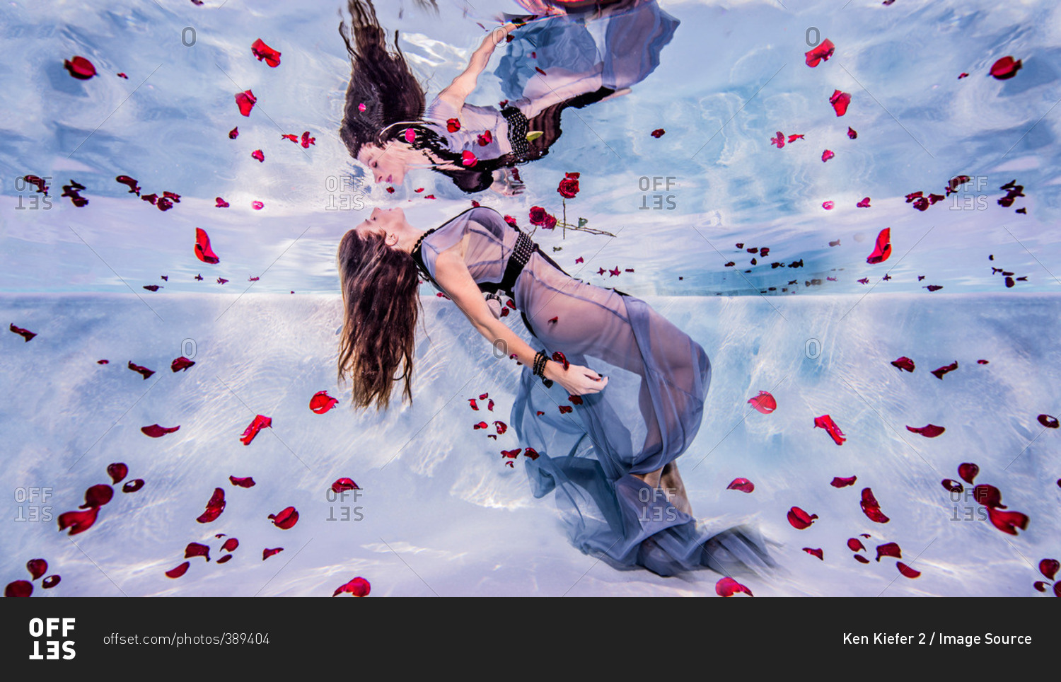 Woman underwater with rose petals