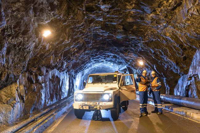 Workers with utility vehicle in tunnel of hydroelectric power station