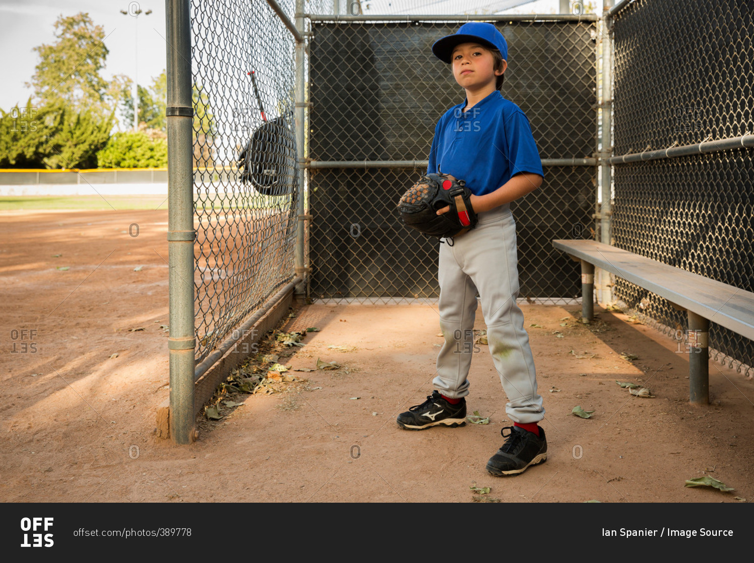 Portrait of boy wearing baseball glove at baseball practice