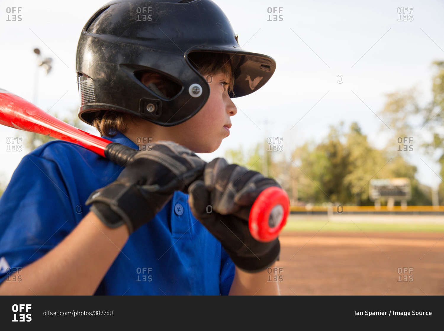 Close up of boy preparing to bat at practice on baseball field
