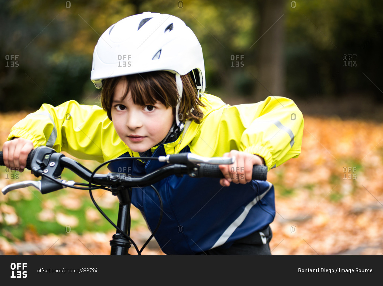 Boy wearing bicycle helmet on bicycle looking