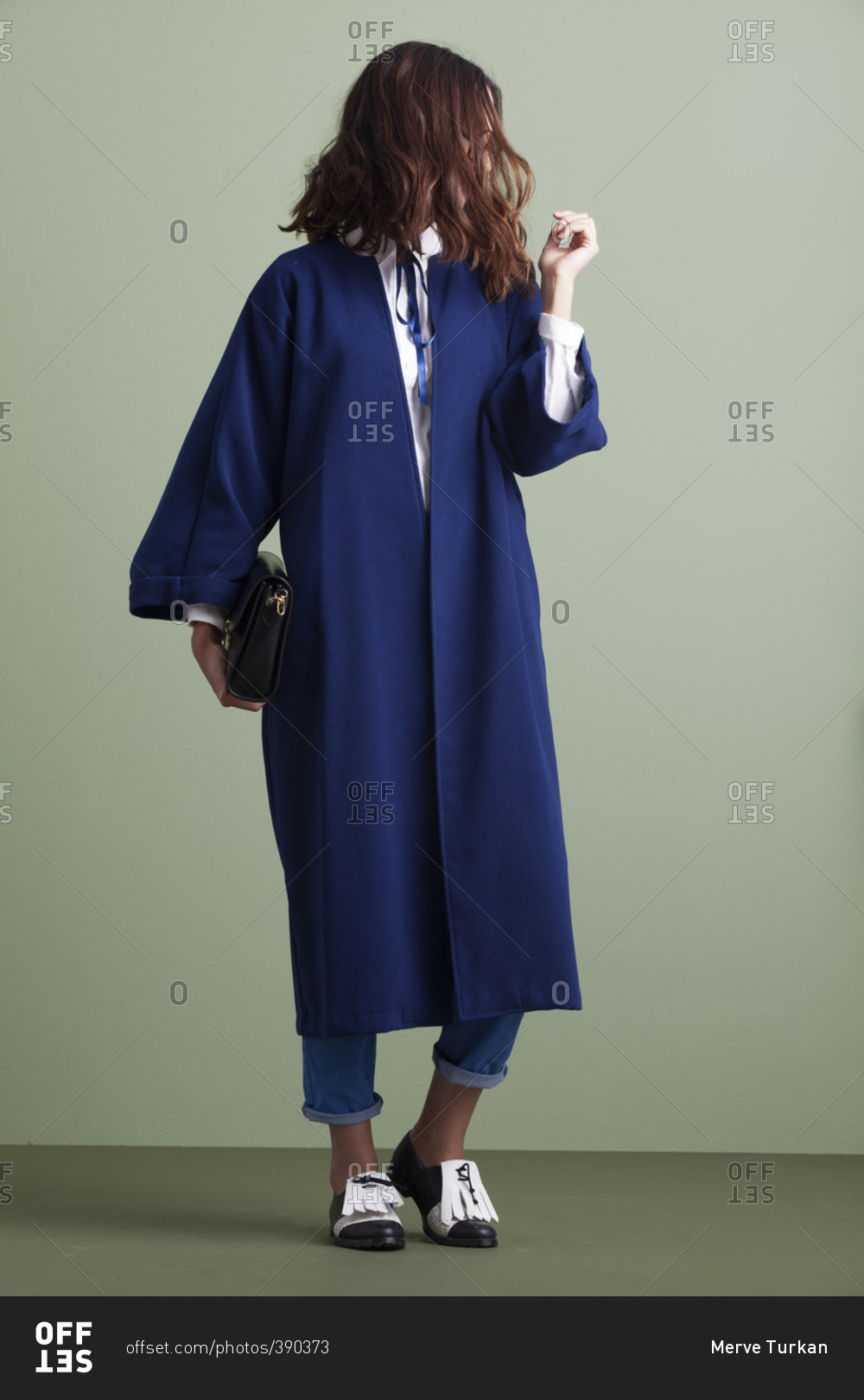 Woman in a blue overcoat and loafers with tassels stock photo OFFSET