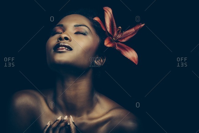 Beautiful woman with red lily in her hair