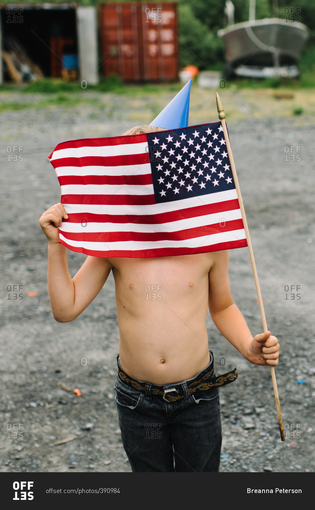 Boy wearing a birthday hat holding the American flag