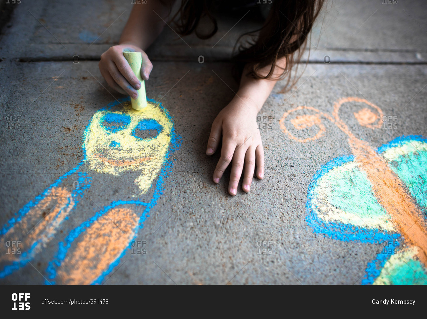 Girl drawing with chalk on sidewalk
