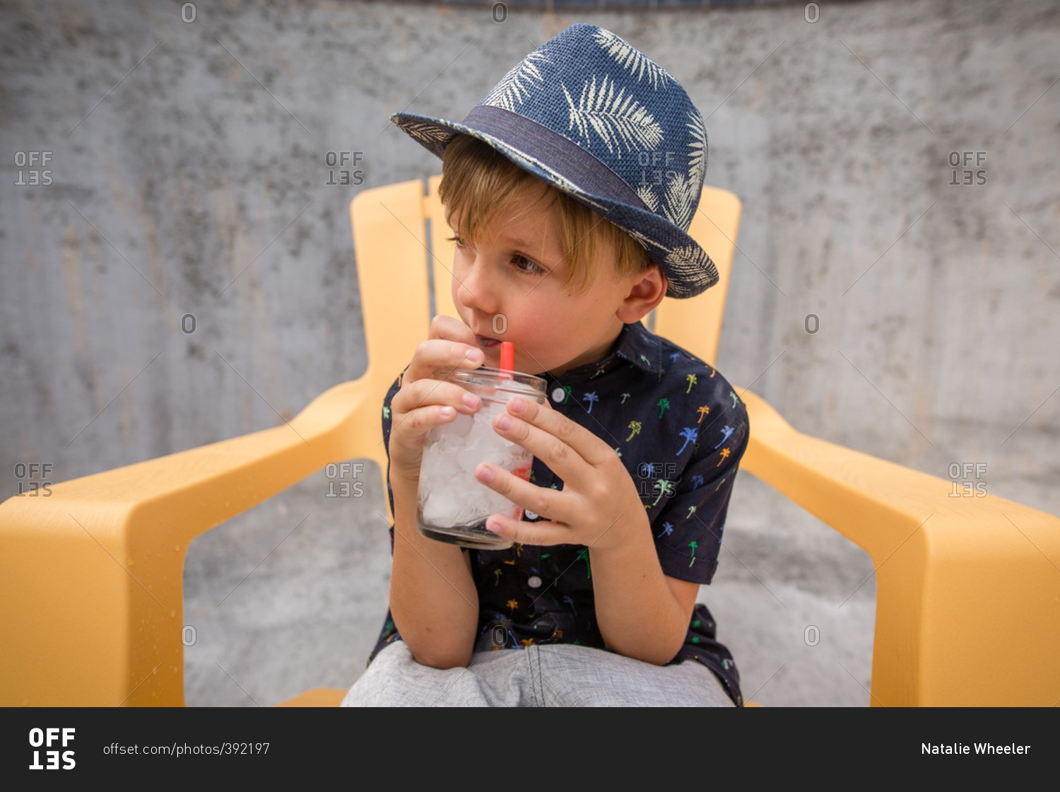 Boy with icy drink in an empty swimming pool