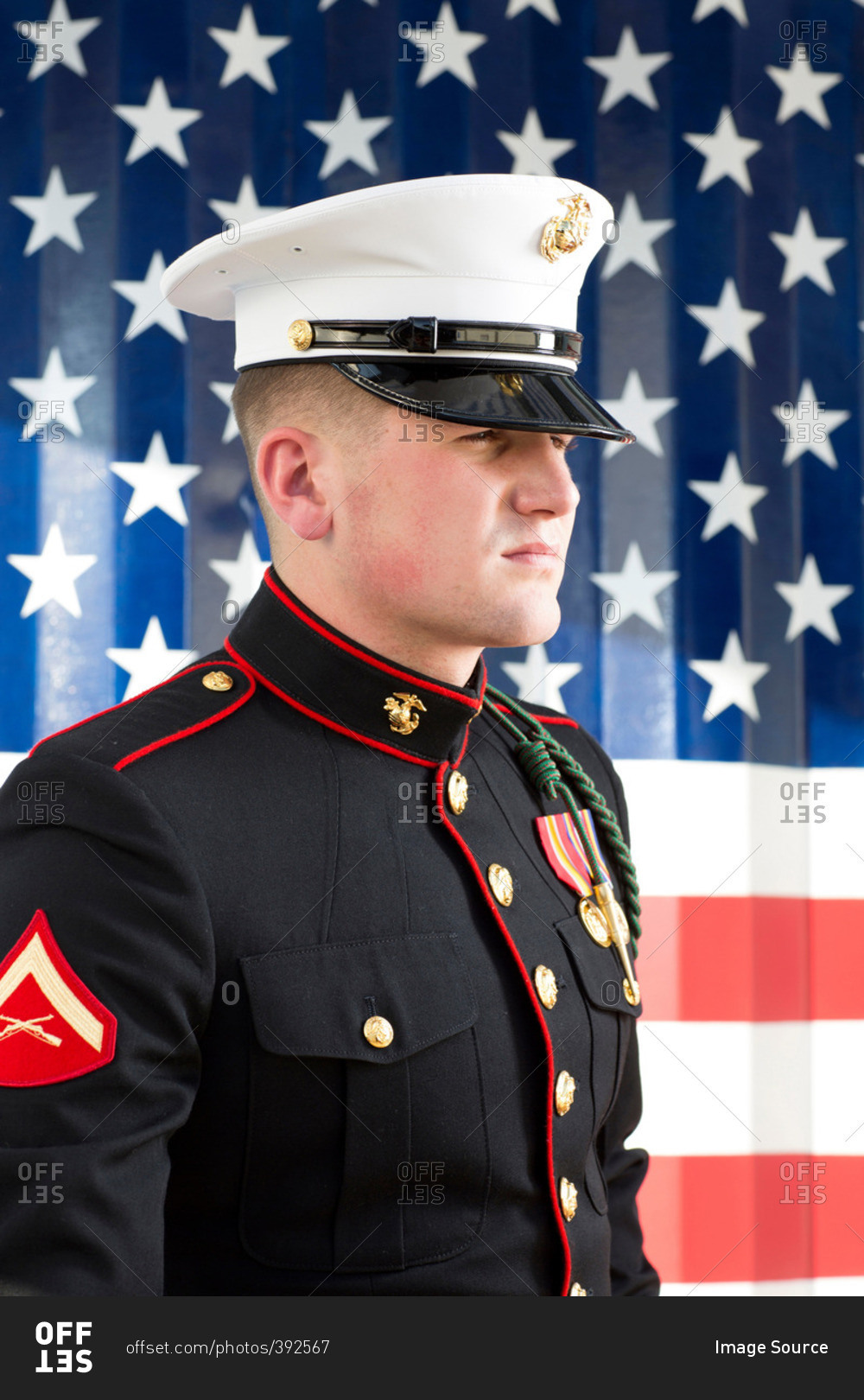 Serviceman in dress blues by US flag