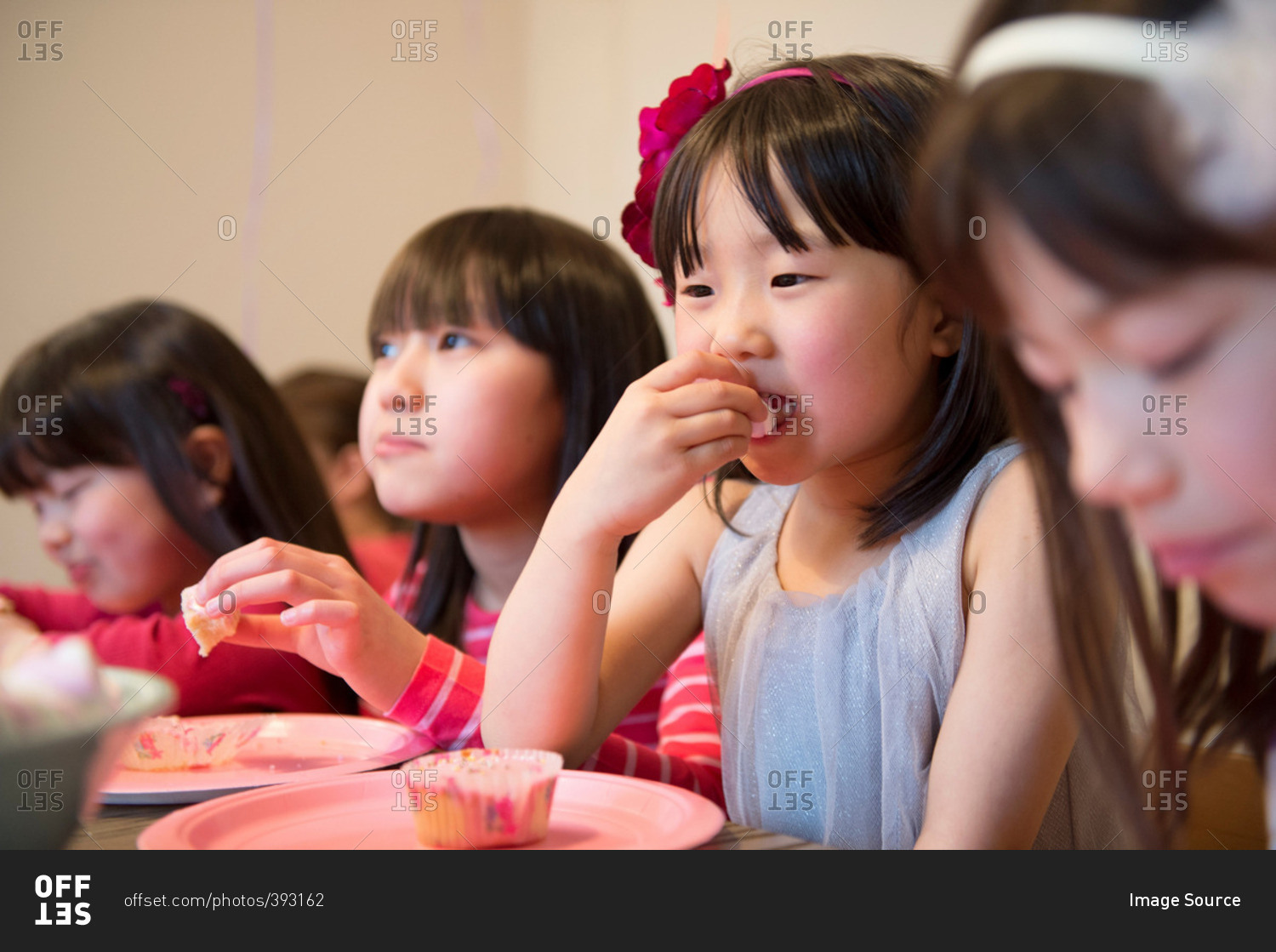 Girl's eating fairy cakes at party
