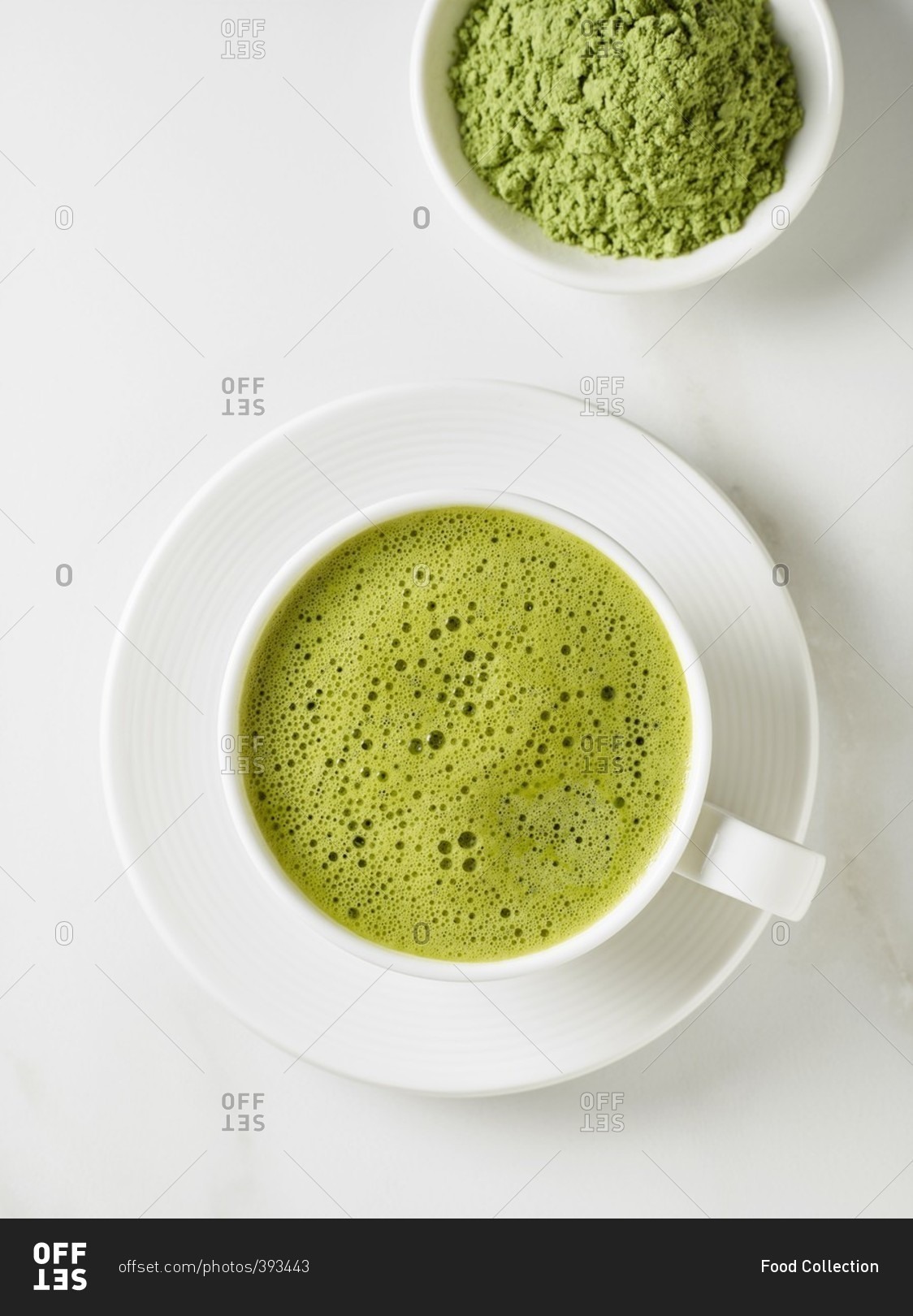 A cup of matcha tea and a bowl of tea powder stock photo - OFFSET