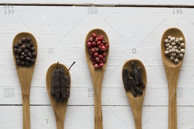 Various types of peppercorns on bamboo spoons